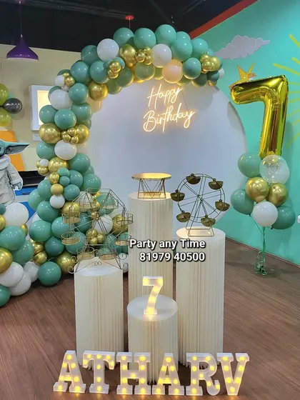 A cute Baby Yoda (Grogu) theme for a 7th birthday, with a character cutout and a green, white, and gold balloon arch.