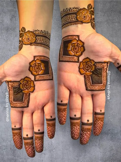 A modern take on party mehendi, this design uses geometric frames to highlight bold, shaded roses on the palms. The fingertips feature a simple crosshatch pattern, creating a contemporary and stylish look.