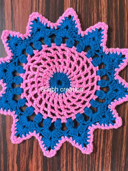 This star-shaped doily combines a pink spiral center with a bold blue border for a vibrant look.