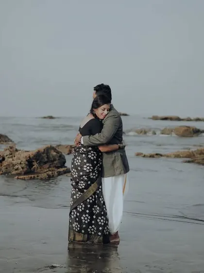 A romantic embrace in the water during a retro-themed beach shoot.