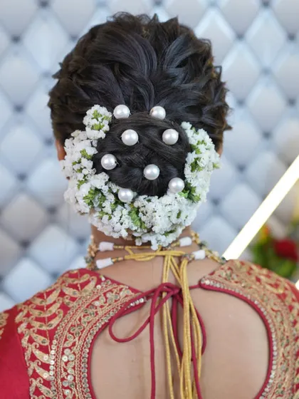 A closer look at the floral bridal bun, showing the detail of the flower and pearl arrangement.