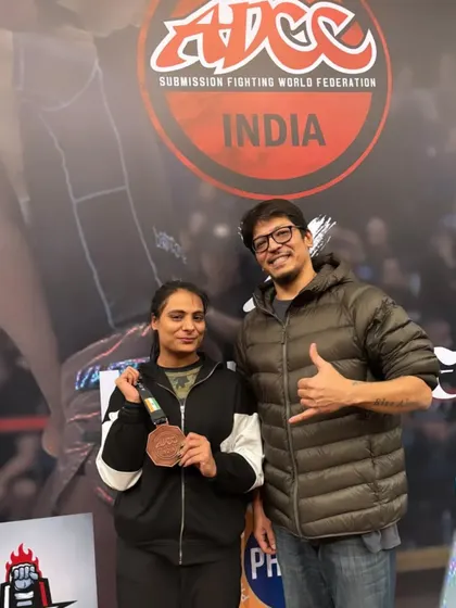 A student and coach celebrating a bronze medal win. Every competition is a learning experience, and we are proud of her for stepping up to the challenge.