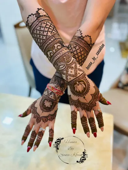 A full bridal design featuring lotus mandalas on the palms and elephant motifs on the arms, combining several auspicious traditional elements.
