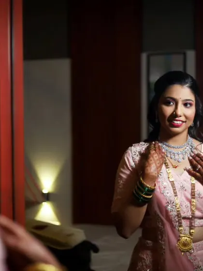 A candid shot of the bride looking at her reflection in the mirror, a smile on her face as she gets ready for her reception. This behind-the-scenes moment is full of anticipation.