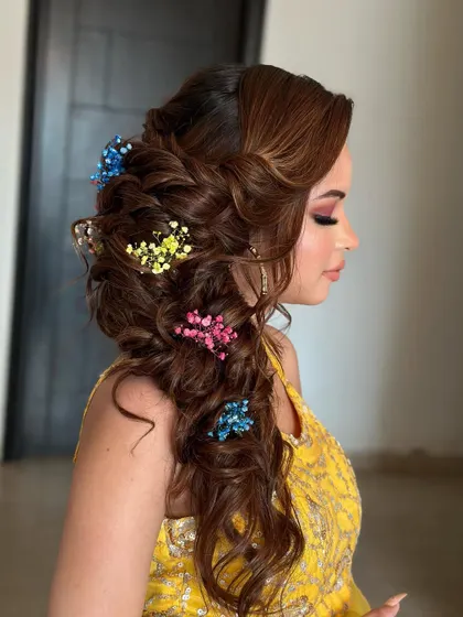 A messy, blooming braid for a Mehendi ceremony. I used colorful baby's breath to match the client's yellow outfit, creating a fun and festive look.