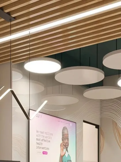 A creative ceiling treatment in the EAII Advisors office, combining a slatted wood ceiling with suspended circular acoustic panels and modern linear lighting fixtures.