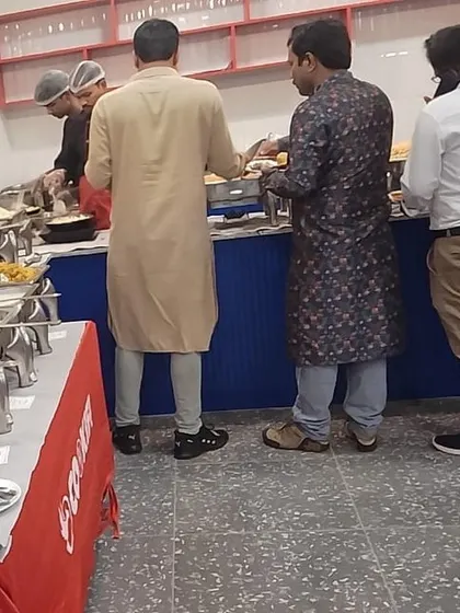 Guests in traditional attire enjoying our buffet during an office festival celebration. We cater to events of all themes and sizes.
