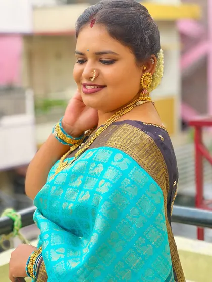 Wrapped in the serenity of blue, this client exudes tranquility and grace. Her makeup is kept soft and natural to complement her beautiful silk saree.