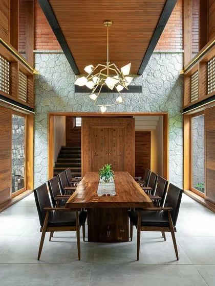This symmetrical view highlights how our courtyard design integrates with the home's architecture. The open-air garden acts as a central lung for the house, visible through large sliding glass doors on either side of the dining area.