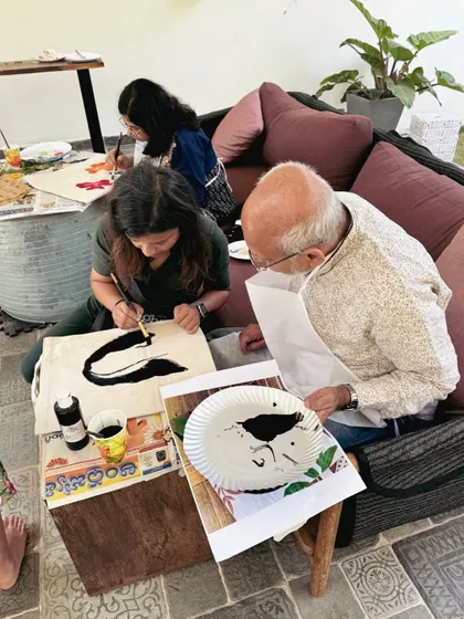 An older gentleman participating in a family painting session. Art truly has no age limit, and it's a wonderful activity for the whole family to do together.