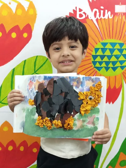 Another happy artist with his finished collage. We encourage every child to interpret the project in their own way, celebrating their unique creative choices.