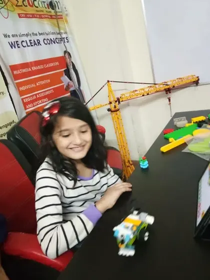 A young girl tests the movement of her coded vehicle. Our classes are filled with moments of discovery and hands-on experimentation.