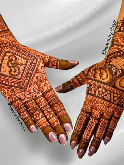 This intricate back-hand design was personalized for the bride. It features a swan couple (a symbol of love) on one hand and the groom's initial on the other, surrounded by detailed patterns.