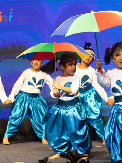 A group of children with umbrellas dances happily, celebrating the life-giving element of water.