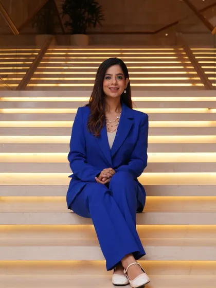 A seated portrait in my blue power suit. This shows a more relaxed but still professional side of my corporate look.