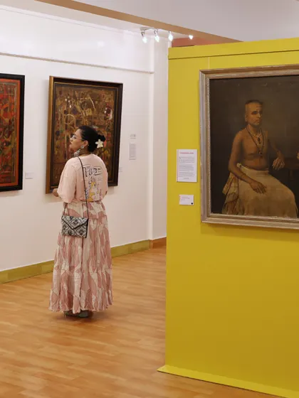A visitor contemplates a historical portrait during the 'The Masters & The Modern: South Edition' exhibition. These quiet moments of connection are what make our work meaningful.