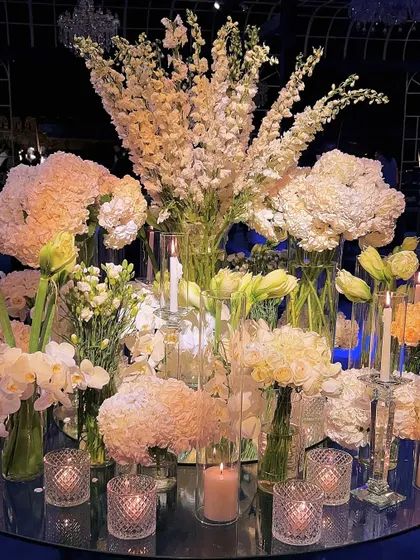 Another perspective of the abundant white floral centerpiece, capturing the soft glow of candles and the intricate layers of different flower varieties. This is where beauty creates a silent, powerful echo.