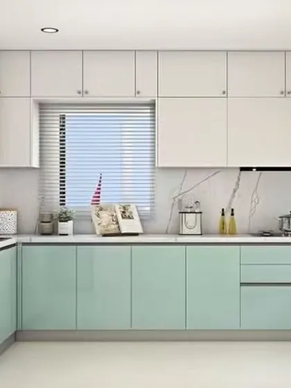 A fresh and modern L-shaped kitchen with mint green base cabinets and crisp white uppers. The marble-effect backsplash and countertop create a clean, continuous surface that is both beautiful and easy to maintain.