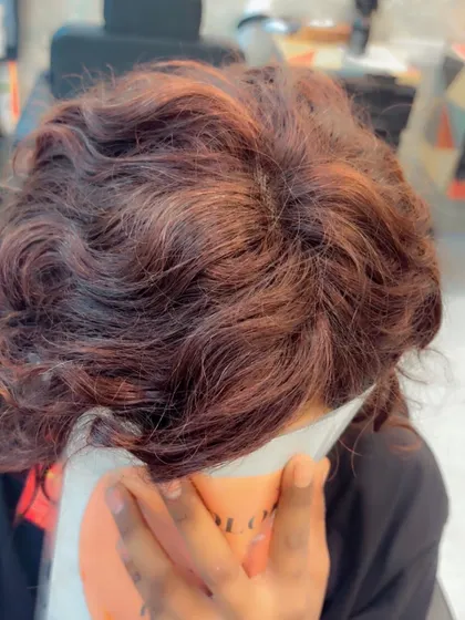A close-up of the scalp on a custom-colored bob wig. Even with curls and color, the parting remains natural and undetectable.