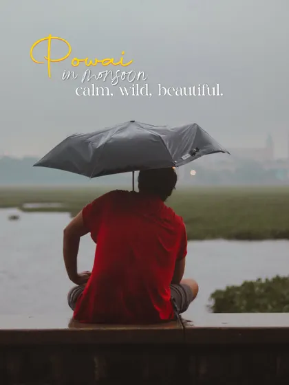 A moment of quiet contemplation by Powai Lake. The rain, the calm water, and a single figure under an umbrella create a scene of perfect peace.