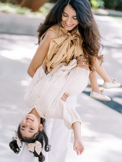 A mother playfully holding her daughter upside down. The laughter and trust in this moment are what I love to capture.