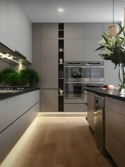 This handleless grey kitchen offers a minimalist and clean aesthetic. I used integrated lighting under the upper cabinets and inside the tall pantry unit to enhance visibility and add a touch of sophistication.