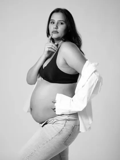 A thoughtful and modern black and white portrait. This pose is both stylish and introspective, capturing the wonder and contemplation of pregnancy.