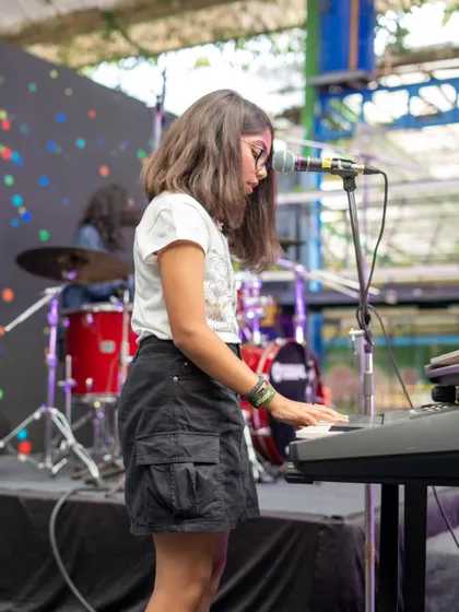 A student pianist completely in her element during the showcase. We ensure every performer gets their moment in the spotlight, backed by a full band and a supportive crowd.