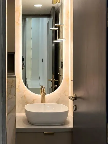 Bathroom goals achieved by mixing metallics, luxurious textures, and a sleek backlit mirror for a glamorous and sophisticated retreat.