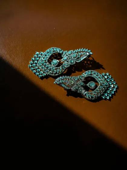 A close-up, artistic shot of a pair of diamond earrings, with dramatic lighting highlighting their sparkle and intricate design.