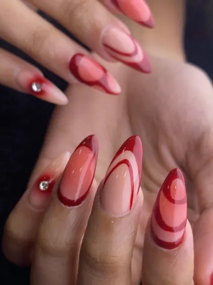 This abstract design uses shades of red in a layered, translucent effect to create depth and movement. A single rhinestone adds a focal point to this artistic set.