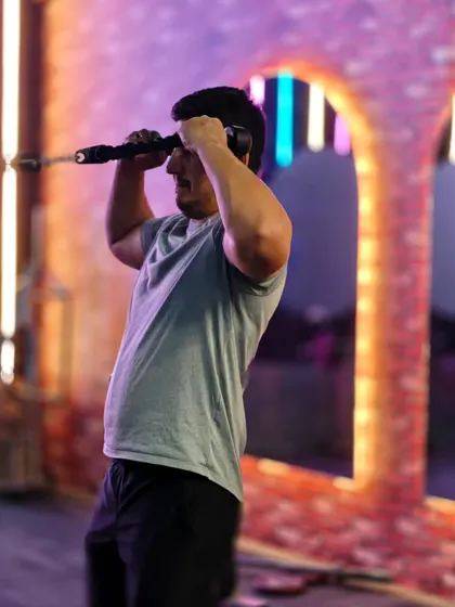 A client works his triceps with a cable pushdown variation. The neon-lit background shows the unique, high-energy vibe of our gym.
