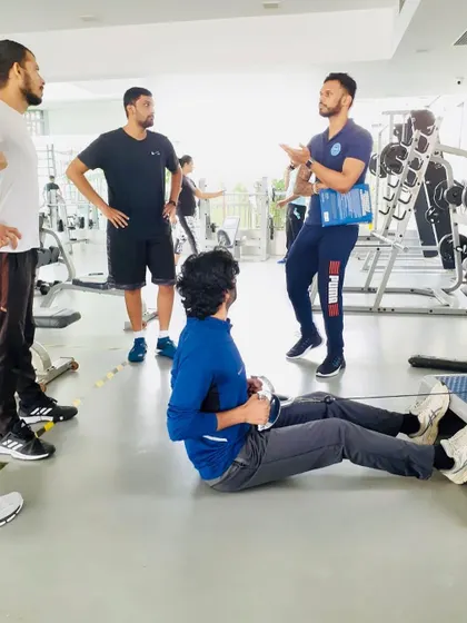 Explaining the mechanics of a seated row to a group of coaches. My teaching method involves clear, concise explanations paired with practical demonstration.