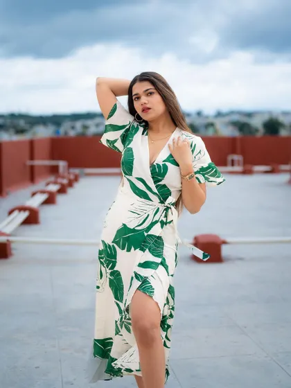 A full-length portrait on a rooftop with the city skyline in the background. The wind in her hair and the open space create a sense of freedom and style.