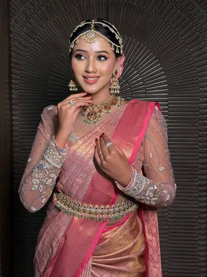 A close-up of the bride's look, showing how the drape of the saree complements her intricate jewellery and flawless makeup.