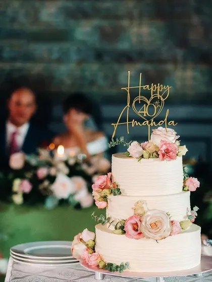 For Amanda's 40th birthday, I designed this elegant three-tiered cake with delicate pink and white roses. The custom gold topper adds a personal touch, making it a perfect centerpiece for a milestone celebration.