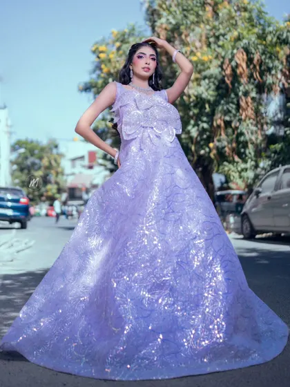 A full-length outdoor shot of the lavender gown, showing its beautiful train and sparkling details under the sun.