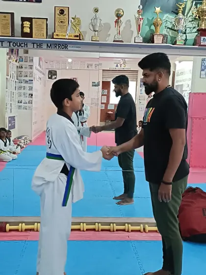 A student receives his green and blue belt.