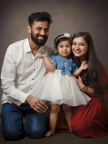 A kneeling family portrait creates a lovely, connected composition. The coordinated outfits and warm smiles make this a cherished memory.