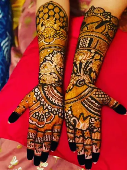 A dense, full-hand design with intricate floral and bird motifs. The dark stain highlights the complexity of the artwork.
