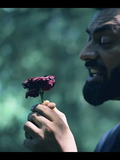 A still from the 'Kurbaan Hua' music video, capturing the raw emotion of the performance. The dying rose symbolizes the song's theme of love and sacrifice.