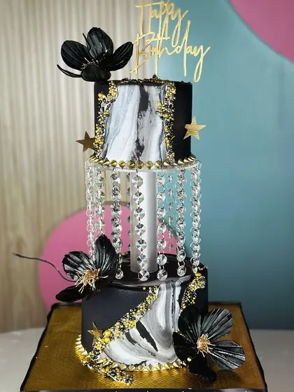 Pure elegance. This breathtaking black and gold chandelier cake is a true masterpiece, designed to be the luxurious centerpiece of a grand celebration.