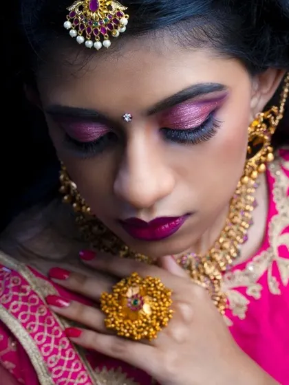 A close-up shot capturing the shimmering pink eyeshadow and bold lip color, perfect for a glamorous bridal look.