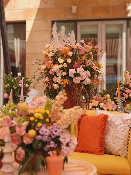 The vibrant yellow sofa is surrounded by lush floral arrangements, creating an immersive and colorful seating experience.