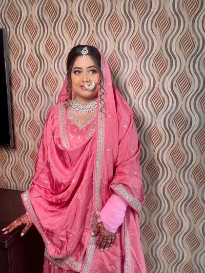 A full view of the bride in her simple yet elegant pink suit, perfect for a morning wedding ceremony.