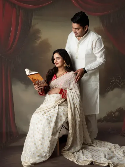 A quiet moment of reading. This portrait, with its theatrical red curtain backdrop, has a classic, literary feel, celebrating a love for stories.