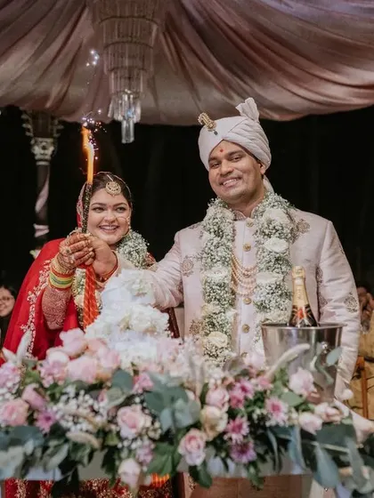 A sweet celebration to mark the beginning of their journey. The couple cuts their wedding cake, surrounded by friends and family, under the warm glow of the reception lights.