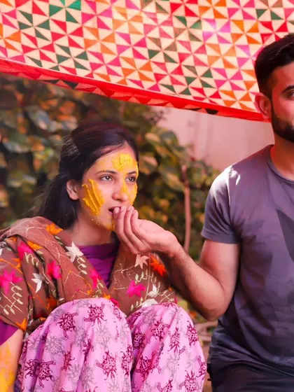 A sweet, candid moment between the couple during the Haldi ceremony. He gently feeds her a bite, a small gesture of love and care amidst the festivities.