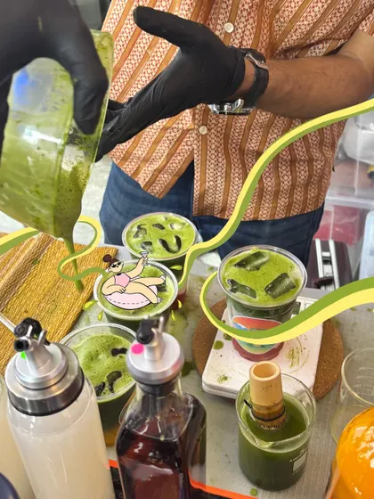A behind-the-scenes look at matcha being made, with a cute doodle of a character relaxing in the drink.