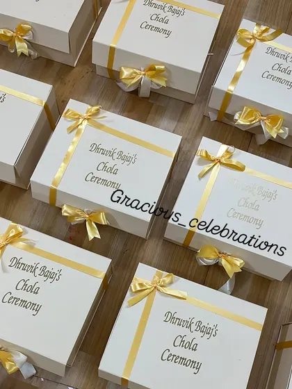 We personalize every detail, right down to the gift box. These elegant white boxes for a Chola ceremony feature the event details in gold foil, finished with a beautiful satin ribbon.